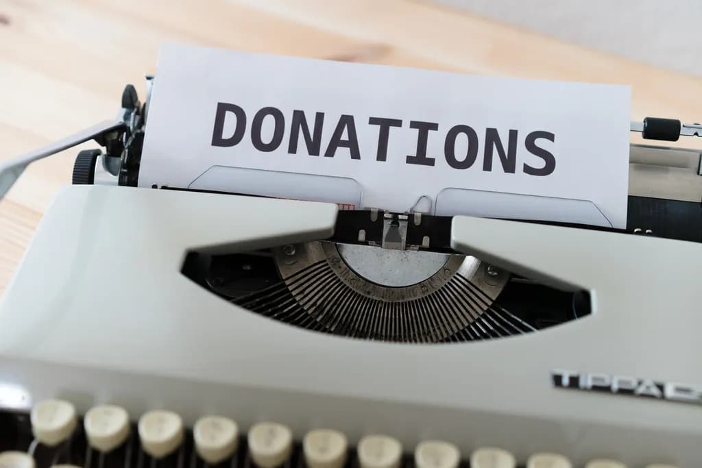 Vintage typewriter with a sheet of paper reading “Donations”